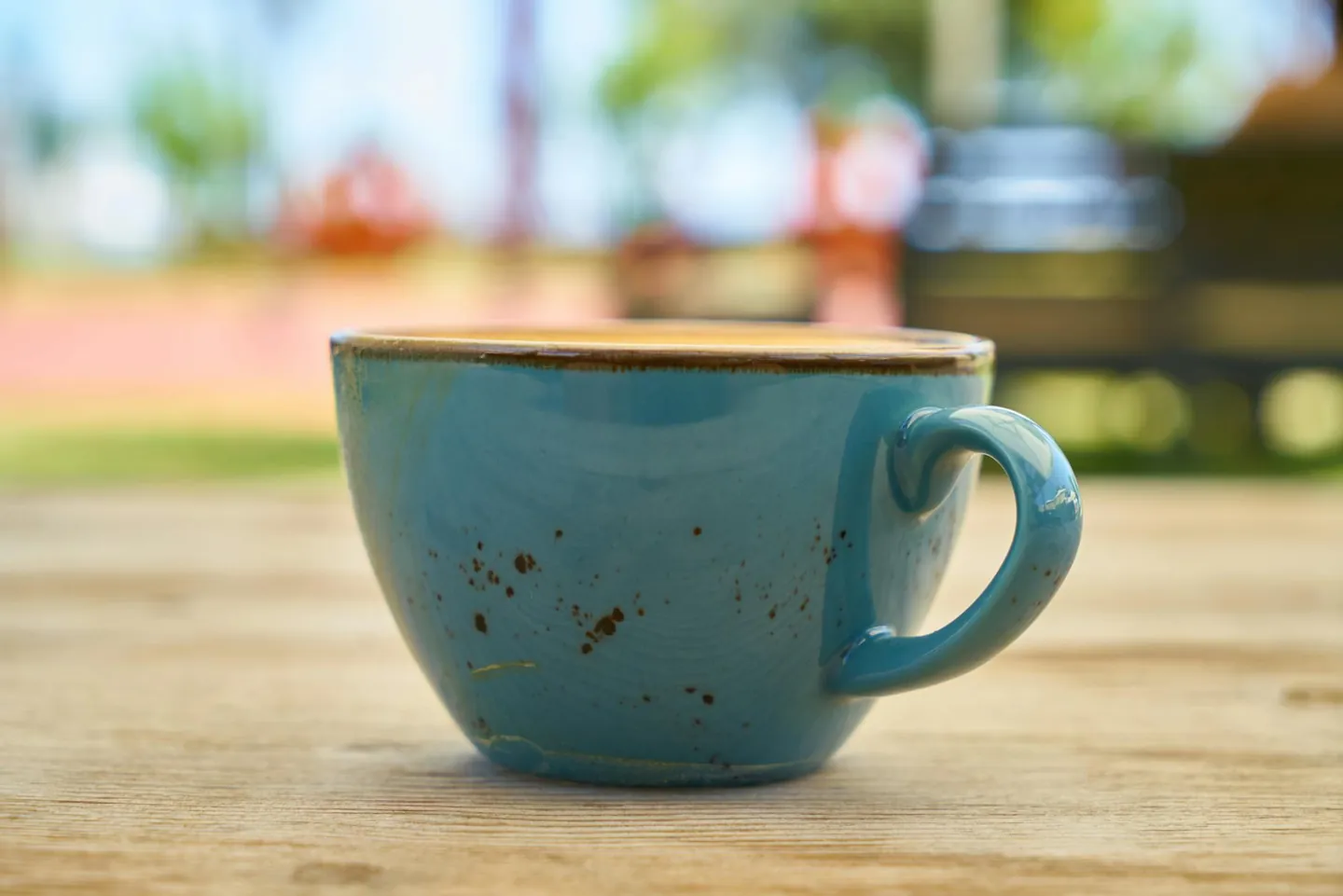 Ceramic mug of coffee on a wooden table, representing a simple coffee habit.