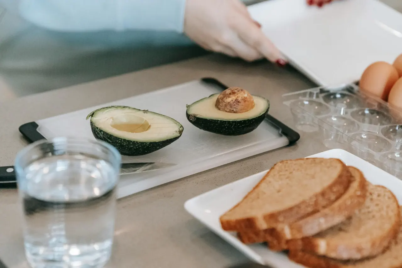 Avocado toast and eggs being prepared in a modern kitchen.