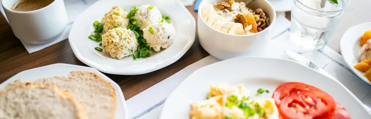 Breakfast spread with eggs, bread, fruit, and other fresh ingredients.