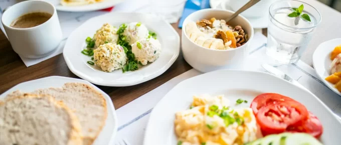Breakfast spread with eggs, bread, fruit, and other fresh ingredients.