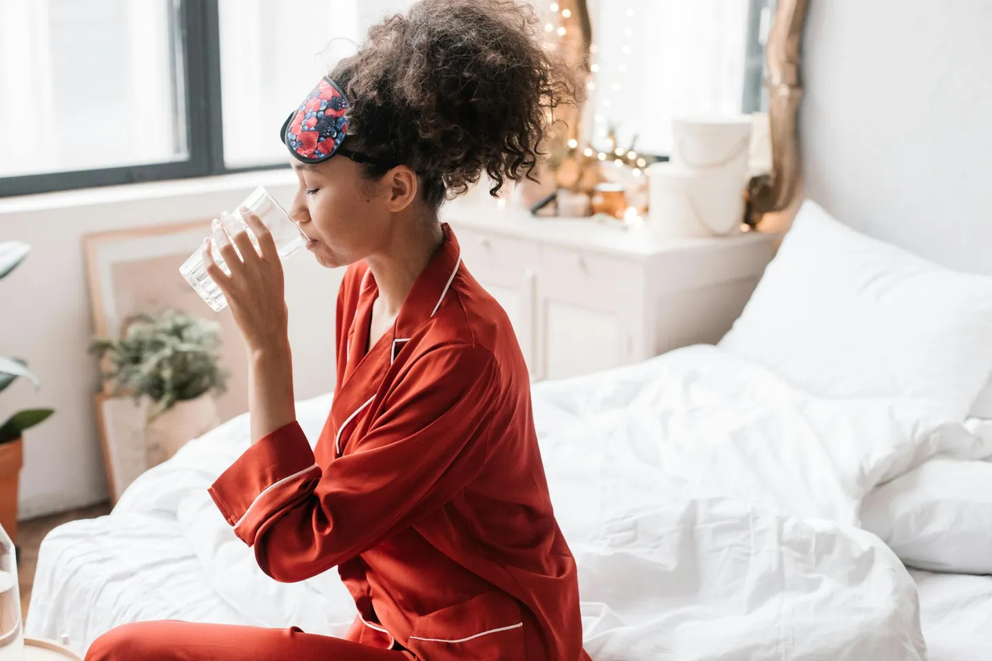 Woman drinking water in the morning, representing a simple hydration habit after waking.