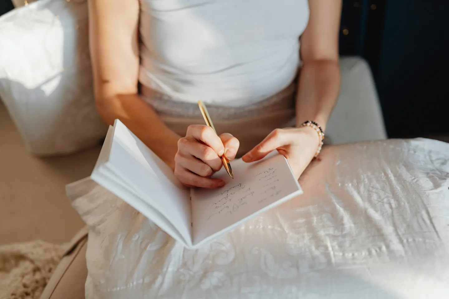 Woman writing in a journal indoors, representing morning planning and intentional focus.