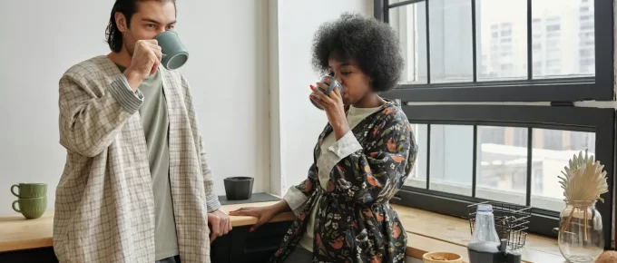 Couple enjoying a healthy breakfast and coffee by a window, representing a calm and productive morning routine.