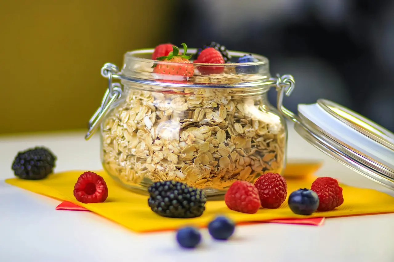 Glass jar of oats with fresh berries, representing a meal-prep breakfast.