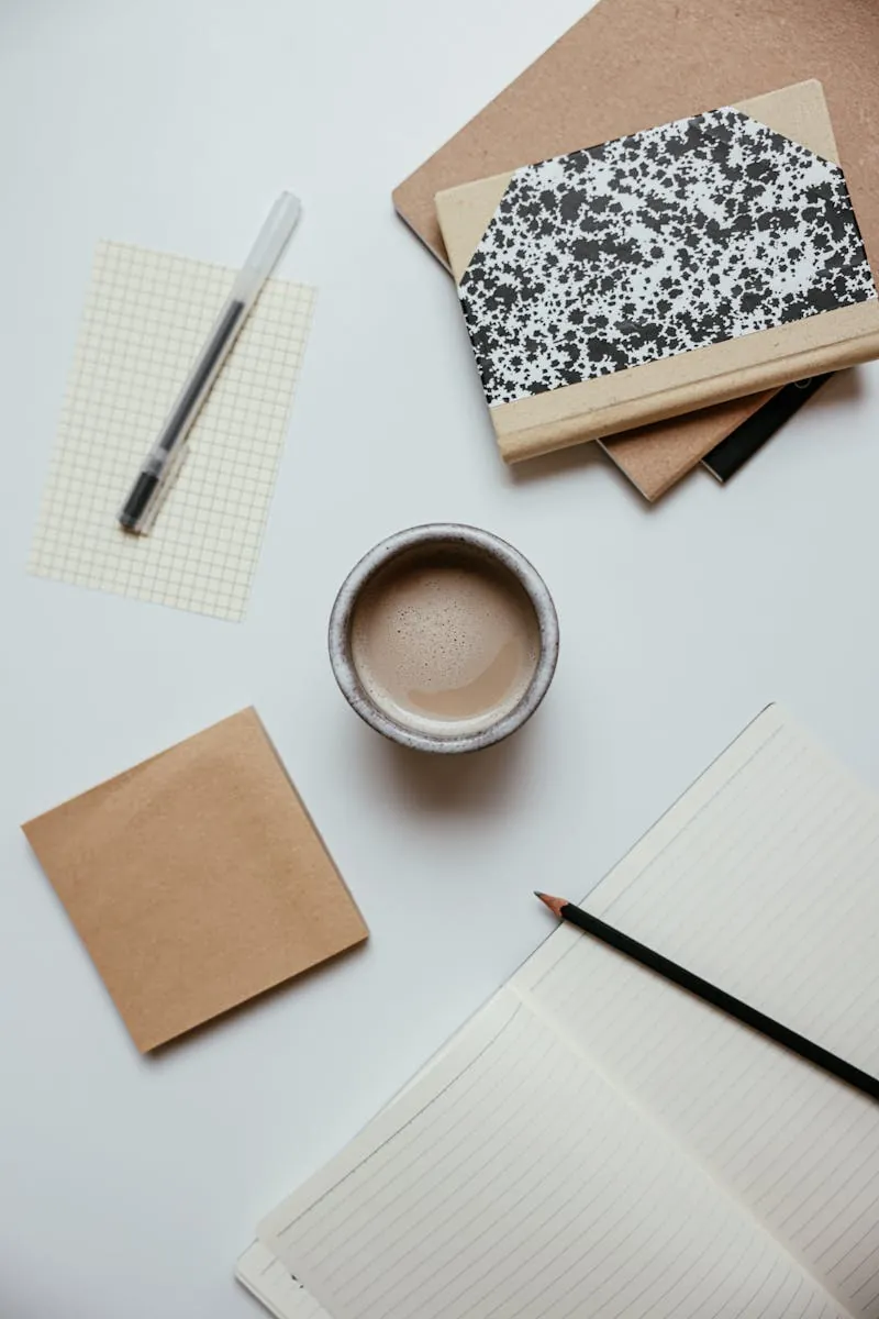 Notebook, coffee, and stationery arranged on a clean desk