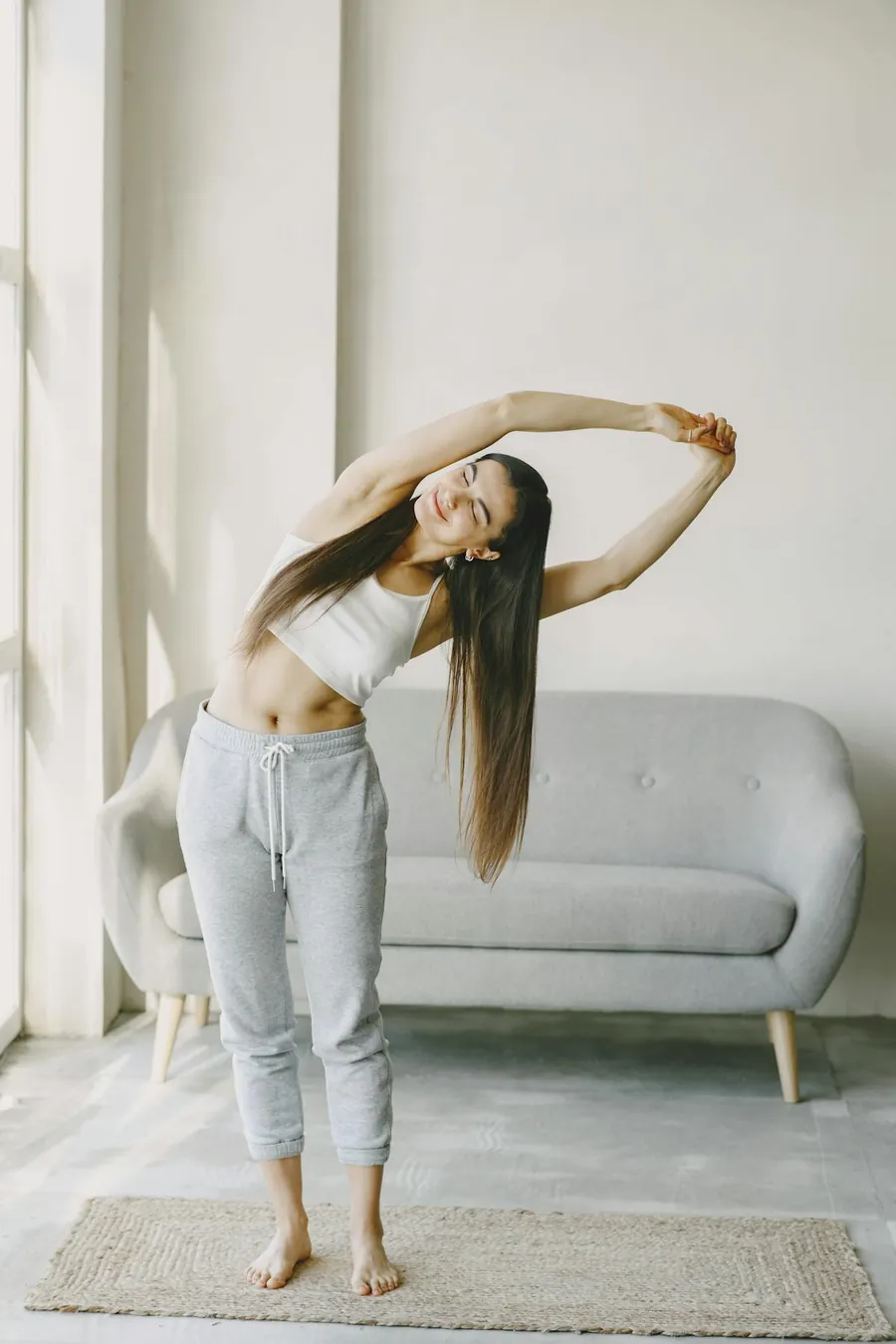 Woman doing a gentle morning stretch in a calm home space