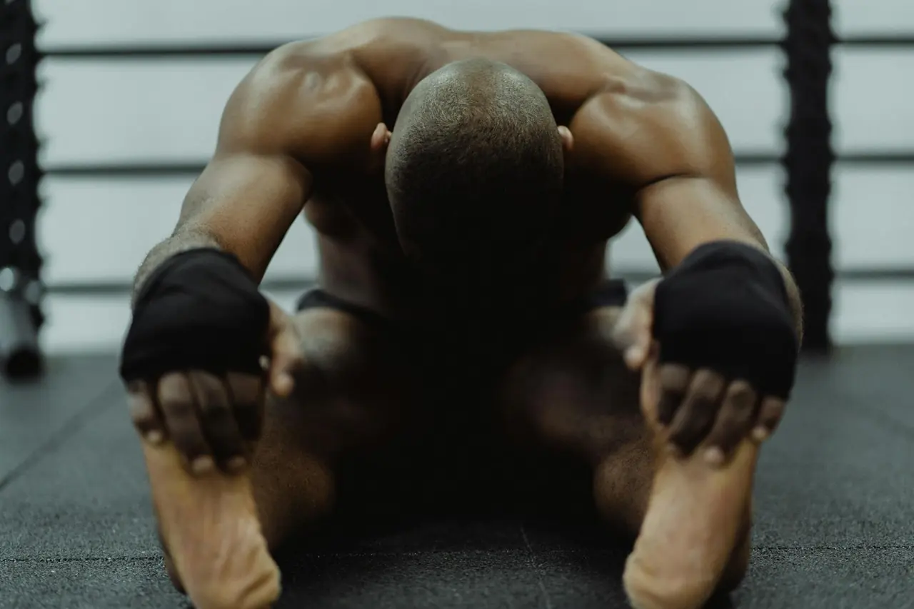 Man sitting on the floor stretching after a workout.