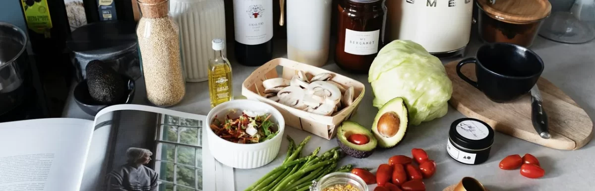 Anti-inflammatory grocery staples like salmon, berries, greens, and olive oil on a kitchen counter