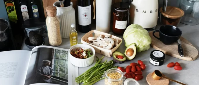 Anti-inflammatory grocery staples like salmon, berries, greens, and olive oil on a kitchen counter