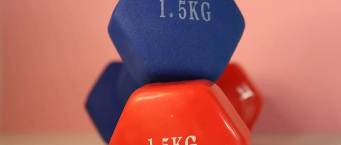 Beginner doing a dumbbell workout in a simple home gym