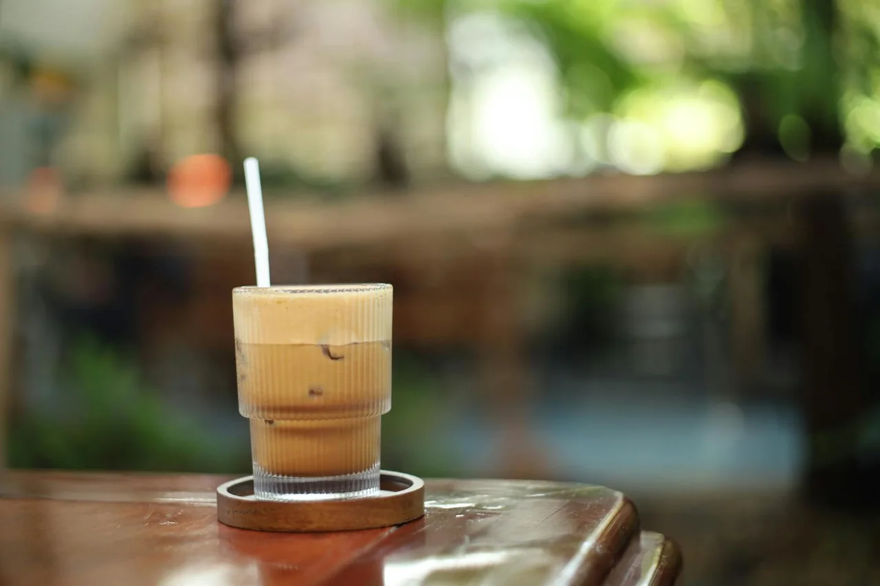 Iced coffee served in a clear glass on a cafe table