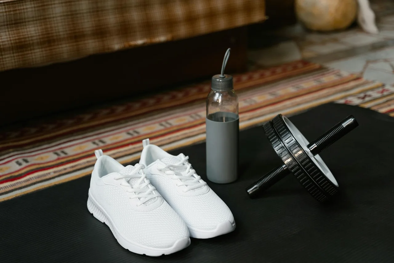 Workout notebook, water bottle, and sneakers ready for training
