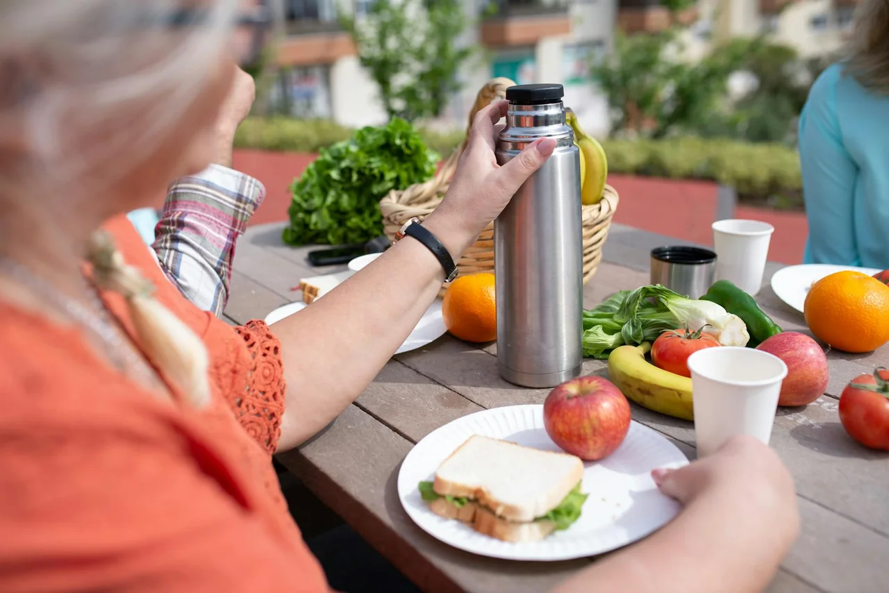 Thermos of soup with sandwich and fruit for an easy office lunch