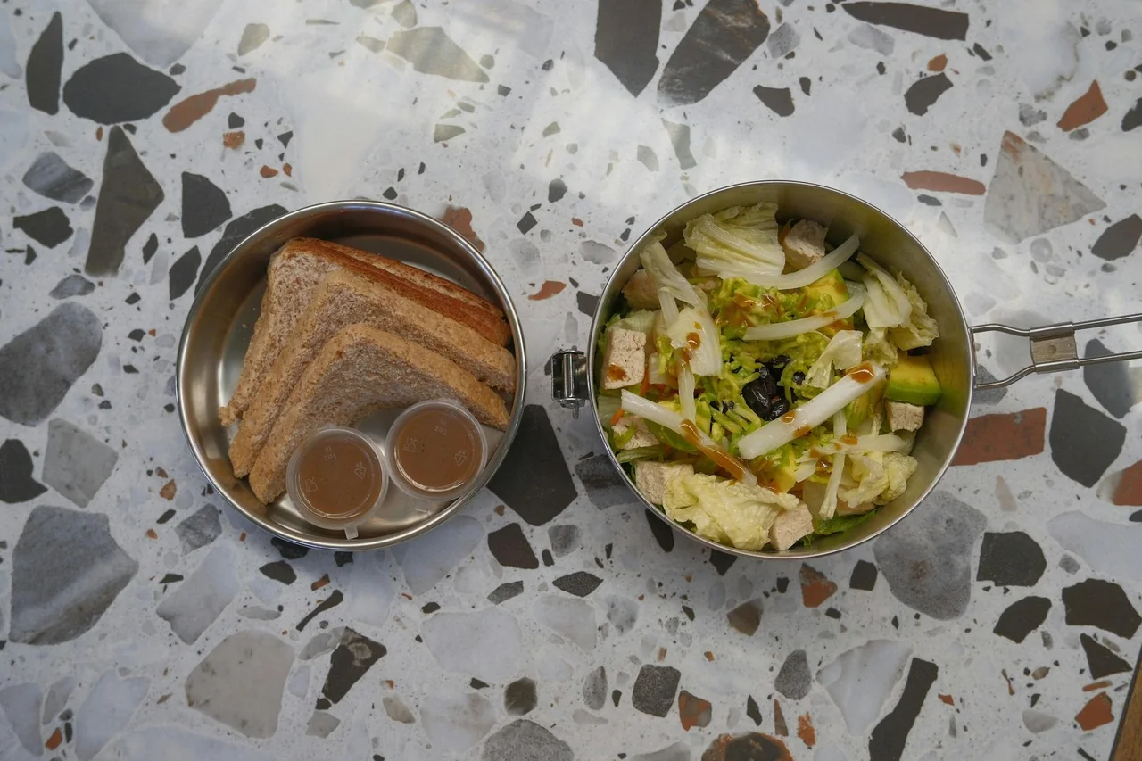 Wrap, salad, and fruit arranged as a work lunch