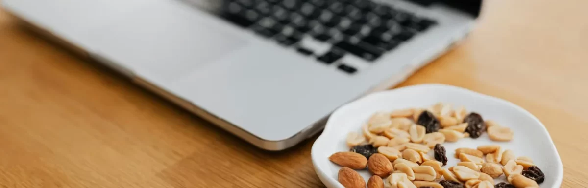 Healthy work snacks arranged beside a laptop on an office desk