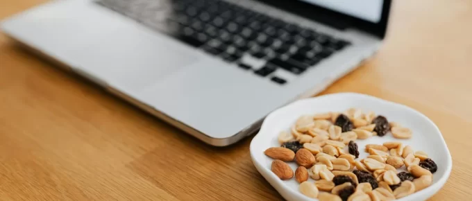 Healthy work snacks arranged beside a laptop on an office desk