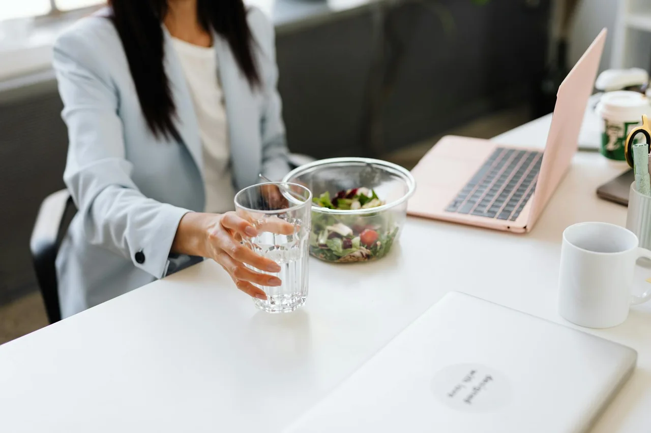 Person drinking water beside a balanced high-fiber lunch