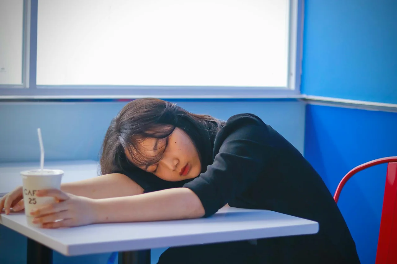 Tired person holding coffee in late afternoon light