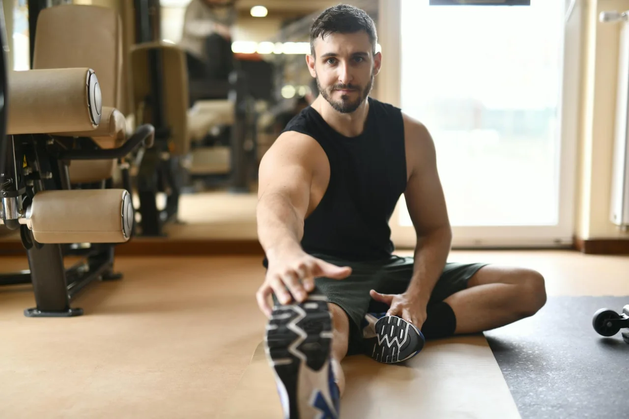 Person stretching after exercise and looking tired