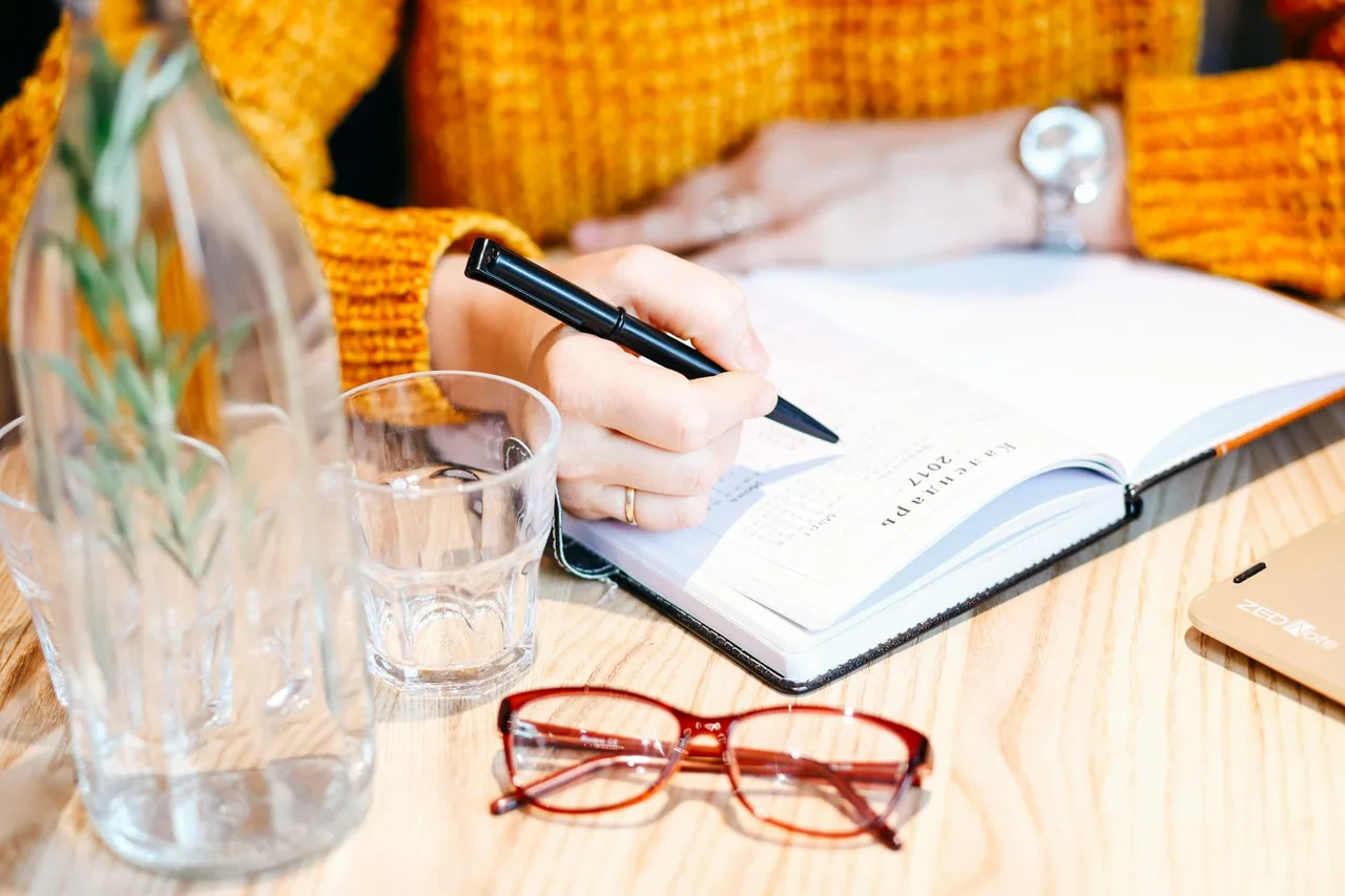 Food journal and glass of water on a table for tracking digestion patterns